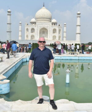 Tourist posing at Taj Mahal in Agra during guided India tour