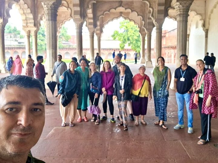 Tourists taking a group selfie at Agra Fort during Overnight Agra Tour from Delhi